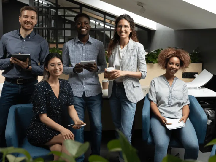 A group of business people standing together in an office.