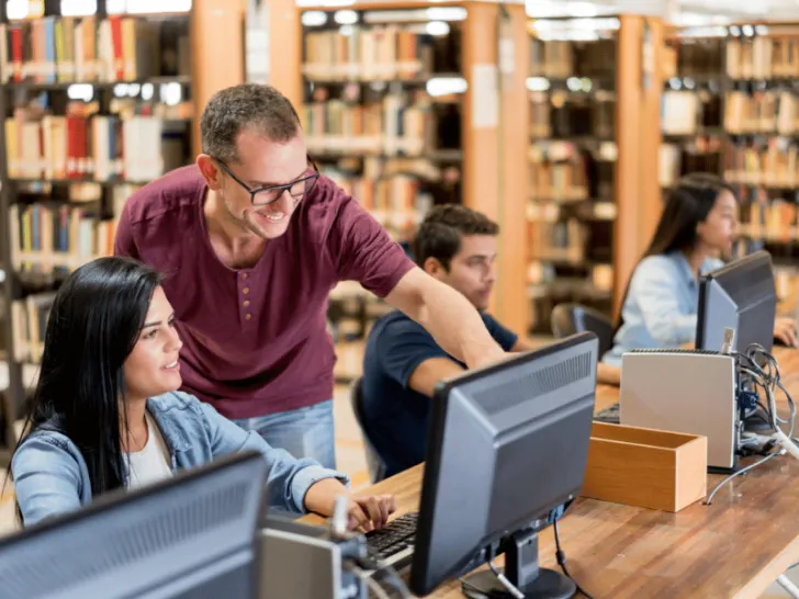 Students using computers in a library to explore how internet enhances daily life.