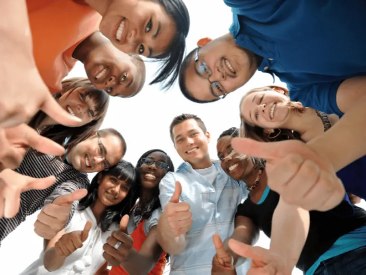 A diverse group displaying positivity through thumbs up gestures.