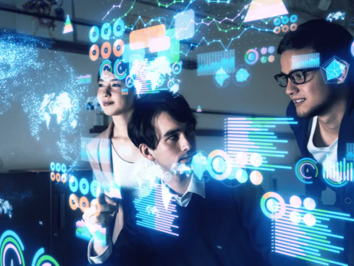 A group of people exploring a computer screen to understand the impact of technology on today's world.