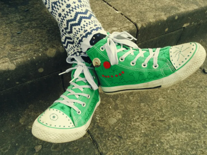 A person wearing green converses.