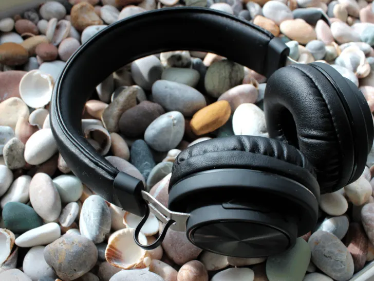 A pair of headphones resting on a rocky surface.