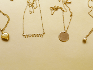 A group of gold necklaces with the word mommy on them, symbolizing favorite color.