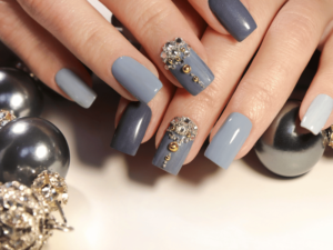 A woman's hand decorated with blue and silver ornaments.