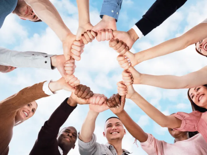 A group of people holding hands in a circle.