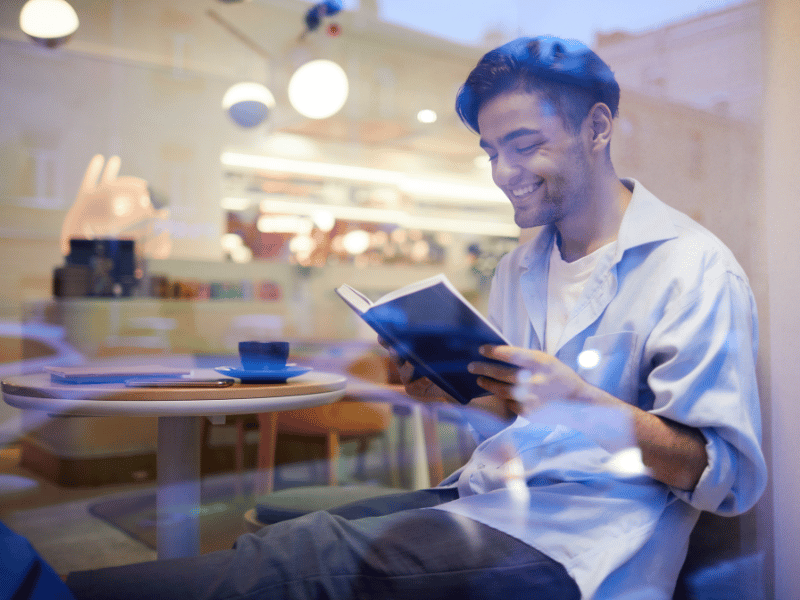 A man sitting at a table reading a funny story.