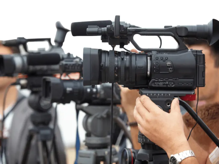 A group of people holding video cameras, practicing journalism and fostering democracy.