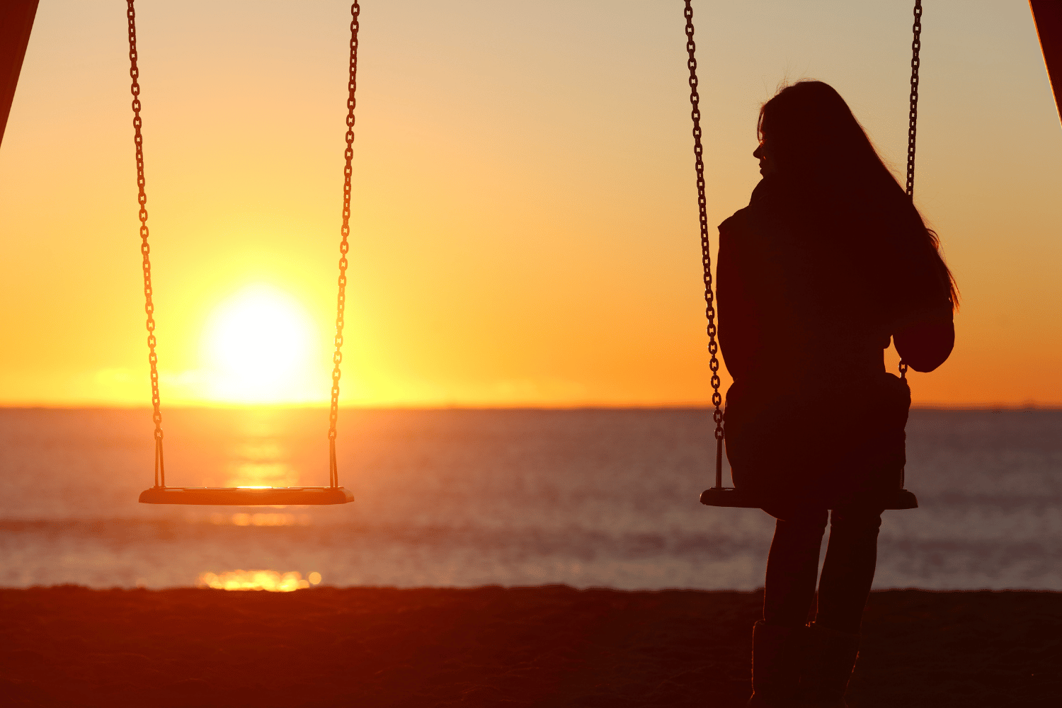 A woman gracefully enjoying solitude on a swing at sunset, embracing the art of being alone.