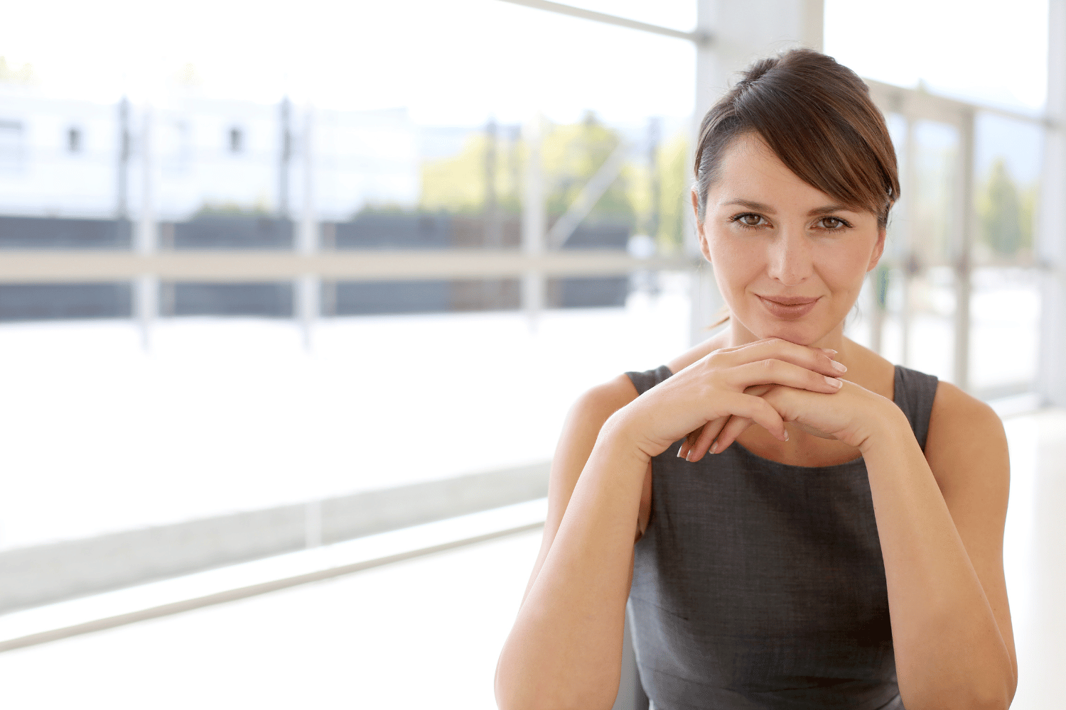 An aspiring entrepreneur sitting at a desk with her hand on her chin.